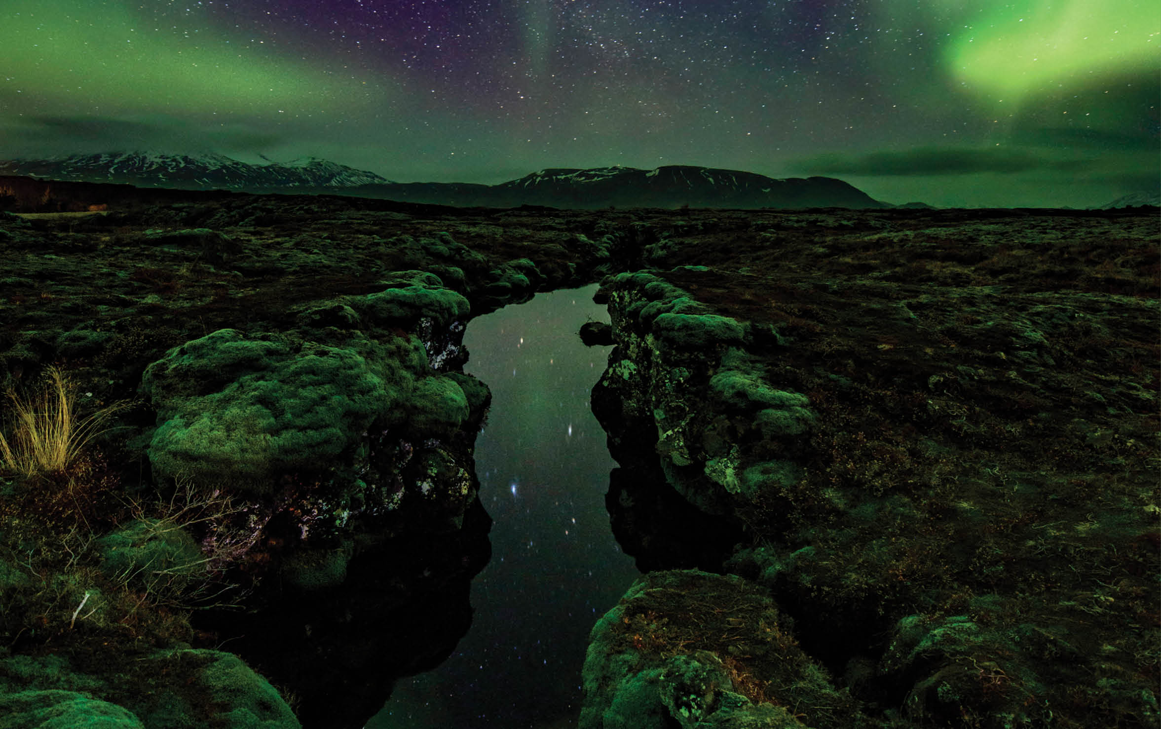 Aurora over the Silfra rift on the tectonic plates which straddle Iceland  The rift is full of gin clear water which is reflecting the aurora 